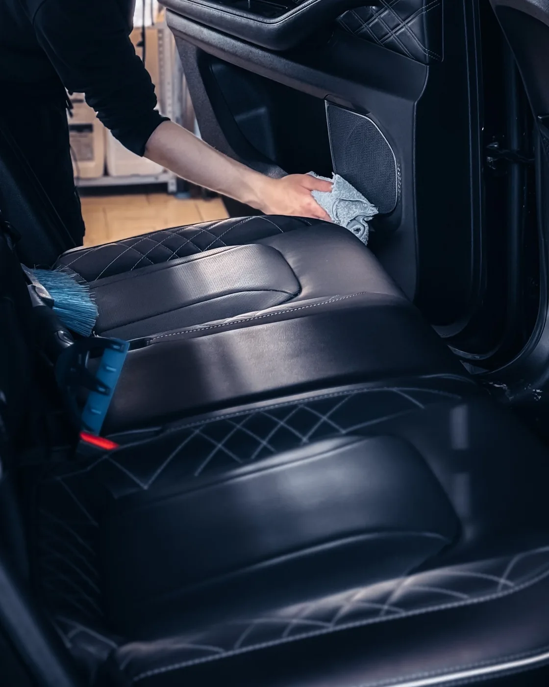 Lederausstattung im Fahrzeugfond wird mit einem Mikrofasertuch gereinigt